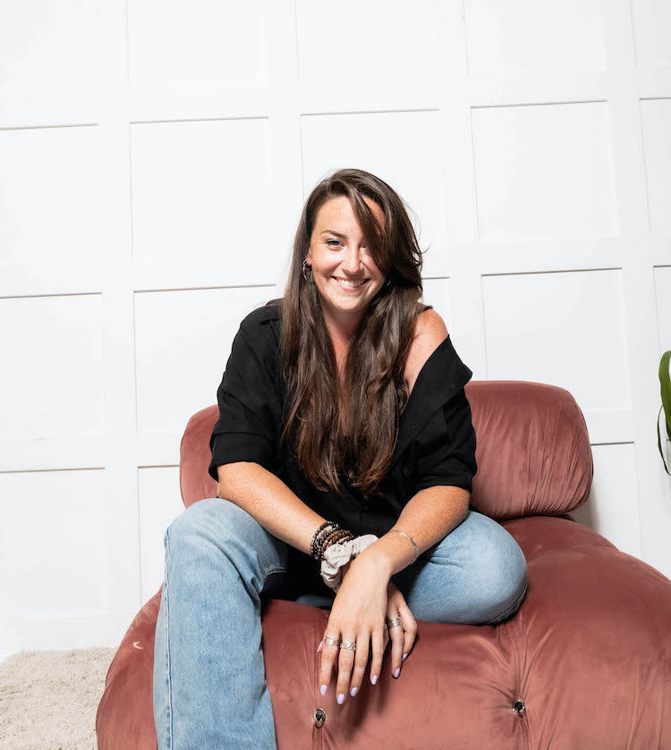 Cassandra Elizabeth, Toronto-based image consultant and clothing stylist, sits confidently in a chair—specializing in personalized style and minimal wardrobes featuring quiet luxury brands.